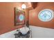 Unique half bath with vessel sink, decorative mirror, stained glass window, and artistic walls at 7138 Avalon Trail Ct, Indianapolis, IN 46250