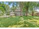 Rear exterior view of home with a fenced yard and a lush lawn with mature trees at 7138 Avalon Trail Ct, Indianapolis, IN 46250
