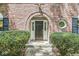 Inviting front door with brick archway, decorative glass, and manicured bushes at 7138 Avalon Trail Ct, Indianapolis, IN 46250
