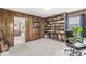 Office space with built-in shelving on two walls, large windows, and space for seating at 7138 Avalon Trail Ct, Indianapolis, IN 46250