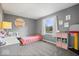 Bright bedroom featuring gray walls, plush carpet, and a sunny window overlooking the yard at 7263 Hidden Valley Dr, Plainfield, IN 46168