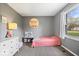 A bright bedroom showcases a soft gray color scheme, plush carpeting, and a window providing natural light and views at 7263 Hidden Valley Dr, Plainfield, IN 46168