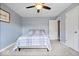 Cozy bedroom featuring light blue walls, ceiling fan, neutral carpet, and a comfortable bed with a plaid blanket at 7263 Hidden Valley Dr, Plainfield, IN 46168