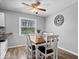 Cozy dining area features wood floors, a ceiling fan, and a large window letting in ample natural light at 7263 Hidden Valley Dr, Plainfield, IN 46168