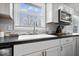 Modern kitchen sink and faucet with bright window featuring white cabinets and stainless microwave at 7263 Hidden Valley Dr, Plainfield, IN 46168