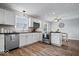 Kitchen with stainless steel appliances and white cabinets opens up to the dining area with wood floors at 7263 Hidden Valley Dr, Plainfield, IN 46168