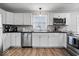 The kitchen features stainless appliances, white cabinets, tile backsplash, and a modern faucet at 7263 Hidden Valley Dr, Plainfield, IN 46168