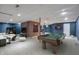 Spacious finished basement with a pool table, a cozy lounge area, and a stylish brick feature wall at 8259 Plumwood Ln, Indianapolis, IN 46256