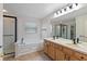 Well-lit bathroom featuring double vanity, soaking tub, and walk-in shower at 8259 Plumwood Ln, Indianapolis, IN 46256