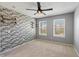 Stylish bedroom with a brick accent wall, contemporary floating shelves, and two bright windows at 8259 Plumwood Ln, Indianapolis, IN 46256