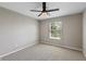 Cozy bedroom with neutral walls, plush carpeting, a modern ceiling fan, and natural light from the window at 8259 Plumwood Ln, Indianapolis, IN 46256