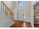 Bright foyer featuring hardwood floors, a staircase, and a large window above the front door at 8259 Plumwood Ln, Indianapolis, IN 46256