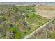 An aerial view displaying the home with a long drive, nestled in a setting of trees and cultivated fields at 8654 N Baltimore Rd, Monrovia, IN 46157