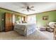 Bright bedroom with green walls, ceiling fan, carpet, and a large bed at 8654 N Baltimore Rd, Monrovia, IN 46157