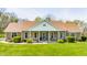 A charming single-story brick home features a well-manicured lawn and a cozy front porch with decorative chairs at 8654 N Baltimore Rd, Monrovia, IN 46157