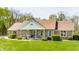 Attractive single-story brick home with a covered front porch, surrounded by greenery, on a sunny day at 8654 N Baltimore Rd, Monrovia, IN 46157