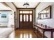 An inviting foyer features a wooden door, hardwood floors, and a console table with decorative accents at 8654 N Baltimore Rd, Monrovia, IN 46157