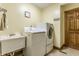 Functional laundry room with a washer, dryer, and a utility sink at 8654 N Baltimore Rd, Monrovia, IN 46157