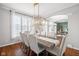 Elegant dining room with a large window, modern chandelier, and seating for six at 8834 Pin Oak Dr, Zionsville, IN 46077