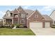 Beautiful brick home featuring an attached two car garage and manicured front lawn at 8834 Pin Oak Dr, Zionsville, IN 46077