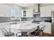 Bright kitchen with white cabinets, modern stainless-steel appliances, and center island with chairs at 8834 Pin Oak Dr, Zionsville, IN 46077