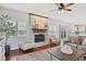 Cozy living room with brick fireplace, hardwood floors, and natural light from large windows at 8834 Pin Oak Dr, Zionsville, IN 46077