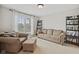 Cozy living room featuring a comfortable sofa, armchair, bookshelves, and natural light from the window at 8834 Pin Oak Dr, Zionsville, IN 46077