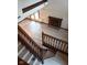 View from the stairs of the open concept living room featuring light vinyl flooring and a fireplace at 8955 Stonegate Rd # A, Indianapolis, IN 46227