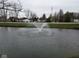Scenic view of the pond featuring a fountain with the community in the background at 8955 Stonegate Rd # A, Indianapolis, IN 46227