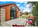 Brick home featuring a charming patio with chairs, landscaping, and sliding door to the interior at 9242 Golden Leaf Way, Indianapolis, IN 46260