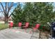 Cozy outdoor patio with red chairs, table, a grill, surrounded by beautiful green trees at 9242 Golden Leaf Way, Indianapolis, IN 46260
