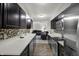 Modern kitchen featuring dark cabinets, stainless steel appliances, and a seamless view into the living room at 9242 Golden Leaf Way, Indianapolis, IN 46260