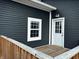 Exterior view of house with white trimmed window, door, a wooden porch and black siding at 109 S County Line Rd, , IN 47272