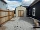 A small shed in a fenced backyard has double doors and fresh gravel surrounding it at 109 S County Line Rd, , IN 47272