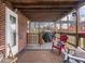Cozy covered back porch with outdoor seating, brick siding, and access to the backyard at 1237 E Pleasant Run Pkwy S Dr, Indianapolis, IN 46203