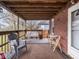 Spacious covered back porch with outdoor seating, charming brick siding, and ample natural light at 1237 E Pleasant Run Pkwy S Dr, Indianapolis, IN 46203