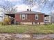 Back exterior view of the brick house with a covered porch and well-maintained backyard at 1237 E Pleasant Run Pkwy S Dr, Indianapolis, IN 46203