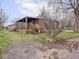 Exterior backyard view featuring a covered porch, lush grass, and charming brick siding at 1237 E Pleasant Run Pkwy S Dr, Indianapolis, IN 46203