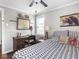 Cozy bedroom featuring a work desk, ceiling fan, and comfortable patterned bedding at 1237 E Pleasant Run Pkwy S Dr, Indianapolis, IN 46203