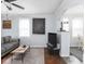 Open-concept living room with hardwood floors, a gray sofa, and a view of the adjacent room at 1237 E Pleasant Run Pkwy S Dr, Indianapolis, IN 46203