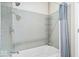 Clean bathroom featuring a tub with tiled walls, a shower head, and a convenient storage rack at 1310 N Chester Ave, Indianapolis, IN 46201