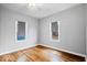 Comfortable bedroom offering hardwood floors, two windows for natural light, and neutral decor at 1310 N Chester Ave, Indianapolis, IN 46201