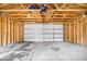 Garage interior with unfinished walls, wooden beams, concrete floor, and white door at 1310 N Chester Ave, Indianapolis, IN 46201