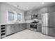 Bright kitchen with stainless appliances, grey cabinets, and marble floors at 1310 N Chester Ave, Indianapolis, IN 46201