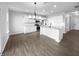 Open kitchen with white cabinets, granite countertops, stainless steel appliances, and a modern pendant lighting fixture at 13211 N Landing W Cir, Camby, IN 46113