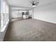 Bright open-concept living room boasts modern ceiling fan and flows into a well-equipped kitchen with island at 13211 N Landing W Cir, Camby, IN 46113