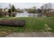 Backyard view showcasing a serene pond with a fountain surrounded by lush greenery at 143 Tracy Ridge Blvd, Whiteland, IN 46184