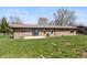 Back exterior showing a brick ranch style home with a large grassy area at 153 Terrace Ct, Franklin, IN 46131