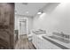 Bathroom features a double vanity, concrete countertops, white cabinets, and wood-look tile flooring at 153 Terrace Ct, Franklin, IN 46131