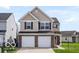 View of the home's front exterior, including a two-car garage and a well-kept lawn at 15444 Old Pond Cir, Noblesville, IN 46060